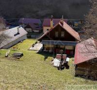 Eine Hütte in Moštenica, umgeben von Rasen und Bäumen.