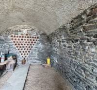 Steinkeller im Weinberg mit Stauraum für Wein und Regal für Behälter.