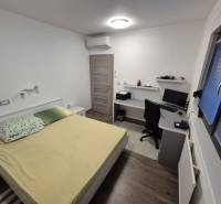 Schlafzimmer im Einfamilienhaus mit Schreibtisch und Boden in Holzoptik.