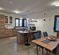 Küche eines Einfamilienhauses mit Holzboden, Tisch und Tafelgeschirr.