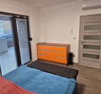 Schlafzimmer im Einfamilienhaus mit Bett, Schrank und Boden mit Holzdekor.