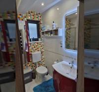 Ein Badezimmer in einem Einfamilienhaus mit farbigen Fliesen und hellen Wänden.