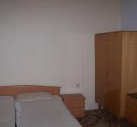 Schlafzimmer in einer 2-Zimmer-Wohnung mit einfacher Einrichtung und Doppelbett.