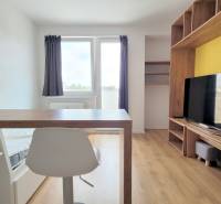 Einzimmerwohnung mit Holzboden, Fernseher und Esstheke.