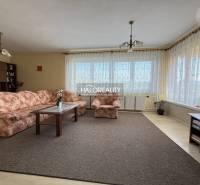 Wohnzimmer mit Teppich, geblümtem Sofa und Holzboden in einem Einfamilienhaus.