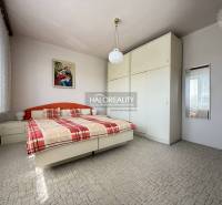 Schlafzimmer in einem Einfamilienhaus mit großem Schrank, Bett und Bild an der Wand.