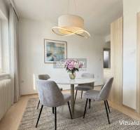 Essbereich in einem Einfamilienhaus mit rundem Tisch und eleganter Leuchte.