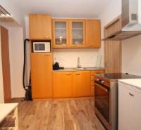 Küche in einer Einzimmerwohnung mit Holzboden, helle Holzschränke.