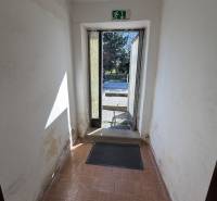 Ein Flur mit älteren Wänden und einem Boden in Holzoptik in einem Einfamilienhaus.