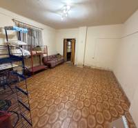 Ein Zimmer in einem Einfamilienhaus mit einem Boden in Holzoptik und einfacher Einrichtung.