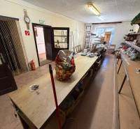 Innenraum eines Einfamilienhauses mit älteren Möbeln und Regalen zur Aufbewahrung von Gegenständen.