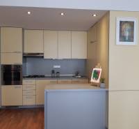 Küche in einer 3-Zimmer-Wohnung mit hellen Schränken und einem Boden in Holzoptik.