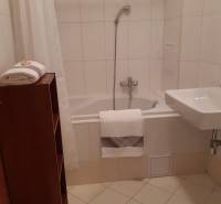 Badezimmer in einer 3-Zimmer-Wohnung mit Badewanne und weißen Fliesen.