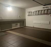 Eine Garage in einem Einfamilienhaus mit Keramikfliesen und einer Leiter an der Wand.