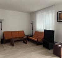 Wohnzimmer in einem Einfamilienhaus mit Holzboden, Sofa und Fernseher.