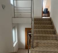 Die Treppe mit Geländer führt in das Zimmer im Einfamilienhaus, weiße Wände.