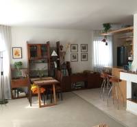 Wohnzimmer mit dunklen Holzmöbeln und Kamin in einem Einfamilienhaus.