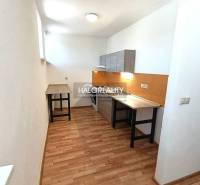 Küche in einer 2-Zimmer-Wohnung mit Holzboden und weißen Wänden.