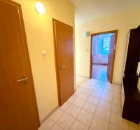 Innenraum einer 2-Zimmer-Wohnung mit Fliesenboden und einem Flur, der ins Wohnzimmer führt.