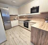 Küche mit Holzboden in einer 2-Zimmer-Wohnung mit moderner Küchenzeile.