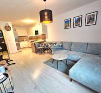 Wohnzimmer mit Ecksofa, Küche und Holzboden in einer 2-Zimmer-Wohnung.