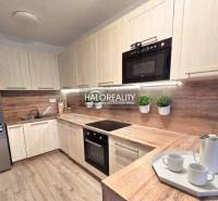 Moderne Küche in einer 2-Zimmer-Wohnung mit Holzdekor und eingebauten Geräten.