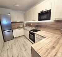 Küche in einer 2-Zimmer-Wohnung mit Holzboden und hellen Möbeln.