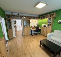 Wohnzimmer in einer Vierzimmerwohnung mit Holzboden und Bücherregal.