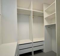 Ein Kleiderschrank mit weißen Einbauregalen und Schubladen in einer 3-Zimmer-Wohnung.