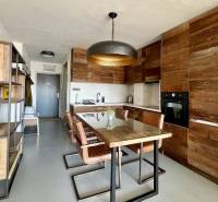 Küche einer 3-Zimmer-Wohnung mit Holzelementen und Esstisch.