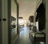 Ein Flur mit einem großen Spiegel, Kleiderhaken und einer Bank in einer 3-Zimmer-Wohnung.