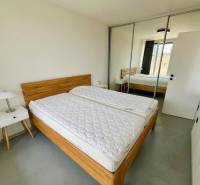 3-Zimmer-Wohnung mit Bett, Schrank, Nachttisch und Spiegeltüren.