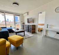 Wohnzimmer einer 3-Zimmer-Wohnung mit Sofa, Fernseher und Balkon.