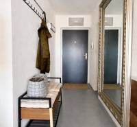 Diele einer 3-Zimmer-Wohnung mit einer Bank, einem Kleiderhaken und einem großen Spiegel an der Wand.