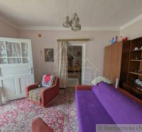 Wohnzimmer in einem Einfamilienhaus mit Teppichboden und Retro-Möbeln.