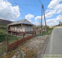 Ein Einfamilienhaus in Zubné mit Veranda, neben der Hauptstraße und in der Nähe einer hügeligen Umgebung.