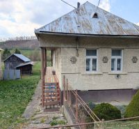 Ein Einfamilienhaus in Zubné mit einem Blechdach, einer Veranda und einem umliegenden Rasen.
