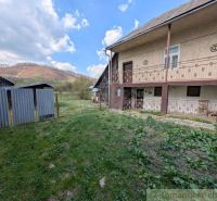 Ein Einfamilienhaus in Zubné mit einem grasbewachsenen Hof und Blick auf die Hügel.