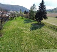 Grünes Grundstück mit Blick auf die Hügel und Bäume in der Nähe von Einfamilienhäusern in Zubné.