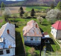 Ein Einfamilienhaus in Zubné, umgeben von Grün und blühenden Bäumen in einer angenehmen ländlichen Landschaft.