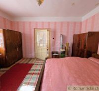 Ein Schlafzimmer in einem Einfamilienhaus mit Retro-Tapeten und Holzmöbeln.