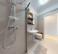 Badezimmer mit einer einfachen Dusche, einem Waschbecken und einer Toilette in einer Einzimmerwohnung.