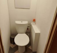 Toilette in einer Einzimmerwohnung mit Fliesen und Hygienebedarf.