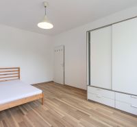 Schlafzimmer in einer 3-Zimmer-Wohnung mit Bett, Schränken und Boden mit Holzdekor.