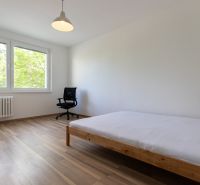 Helles Schlafzimmer in einer 3-Zimmer-Wohnung mit Holzboden und großen Fenstern.