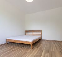 Schlafzimmer mit Bett, Boden mit Holzdekor, in einer 3-Zimmer-Wohnung.