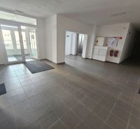 Eingangsbereich mit grauen Fliesen und Glastüren in einer Einzimmerwohnung.