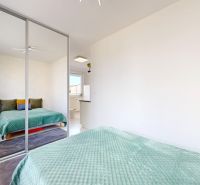Einzimmerwohnung mit Bett, Spiegelschrank und Bücherregal.