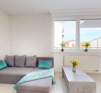 Wohnzimmer in einer Einzimmerwohnung mit Ecksofa und Couchtisch.