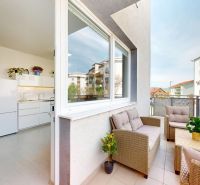 Balkon einer Einzimmerwohnung mit Rattanmöbeln und Blick auf die Umgebung von Slovenský Grob, Koceľova.